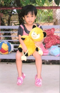 Thien Thanh clinging to the yellow teddy.